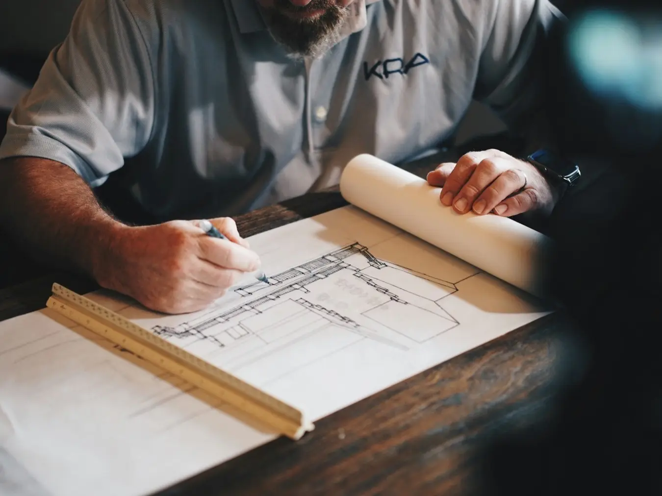 Architecte annotant un plan sur une table de chantier